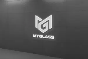 Réception de MyGlass avec logo en relief sur un mur noir, reflétant l'élégance et l'innovation de l'entreprise spécialisée en réparations parebrise.